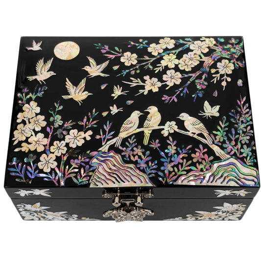Black jewelry box with iridescent bird and blossom inlay under moonlight