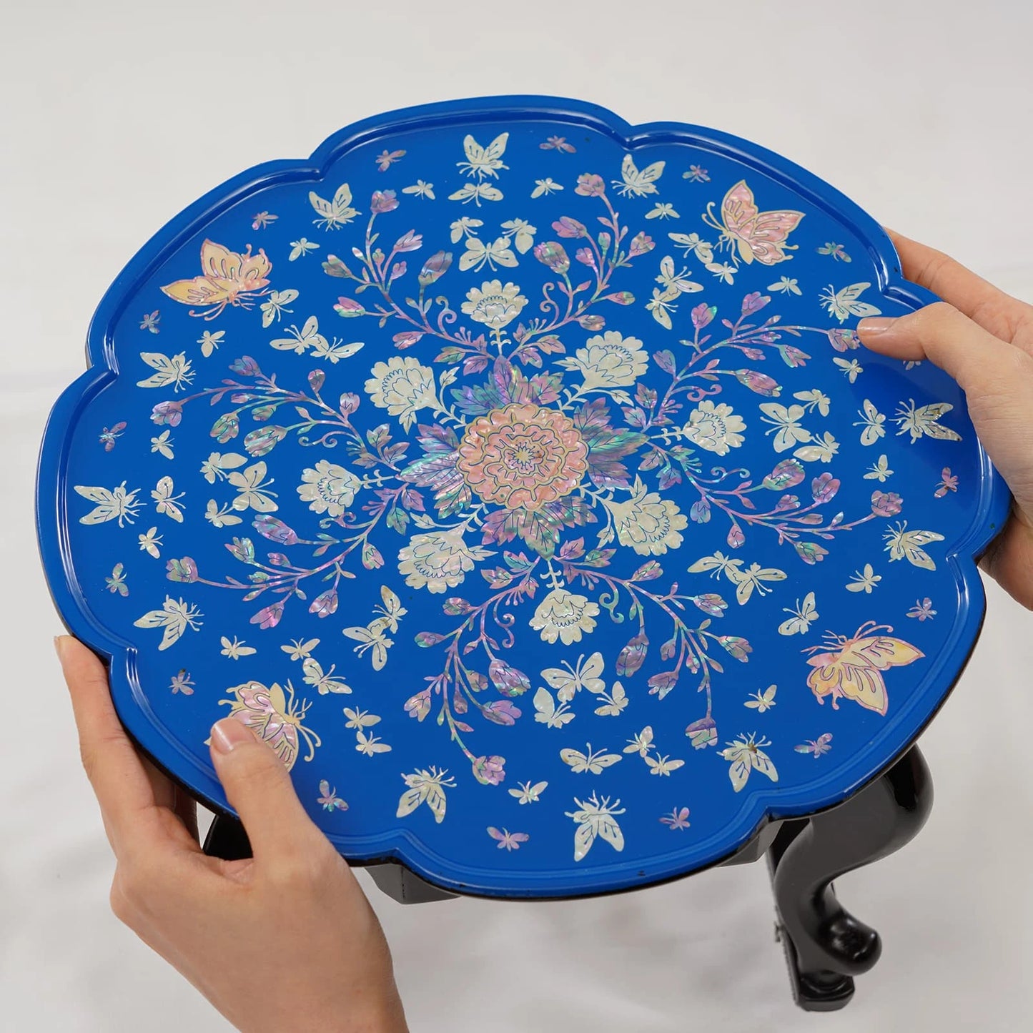 Blue lacquer Korean tray table with iridescent mother of pearl inlay, shown with ceramic teapot and teacup on curved legs