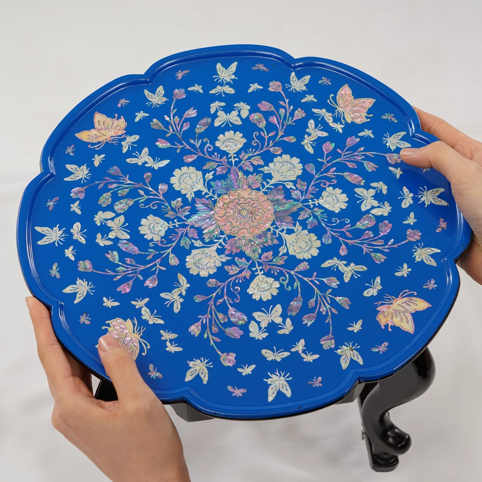Blue lacquer Korean tray table with iridescent mother of pearl inlay, shown with ceramic teapot and teacup on curved legs
