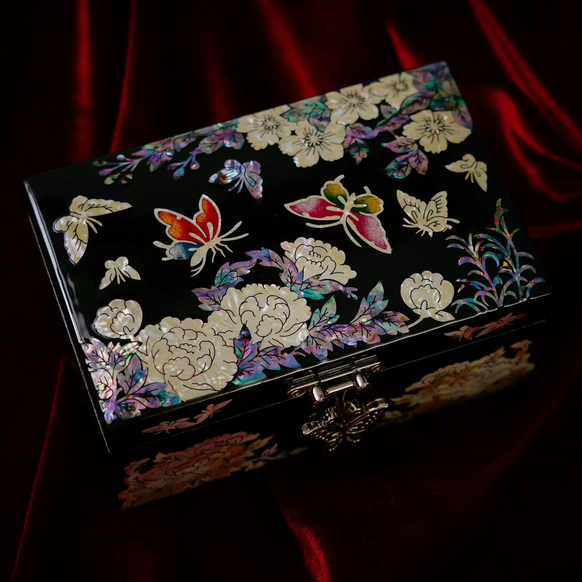 Butterfly and peony mother of pearl jewelry box, black lacquer on red velvet, angled top view