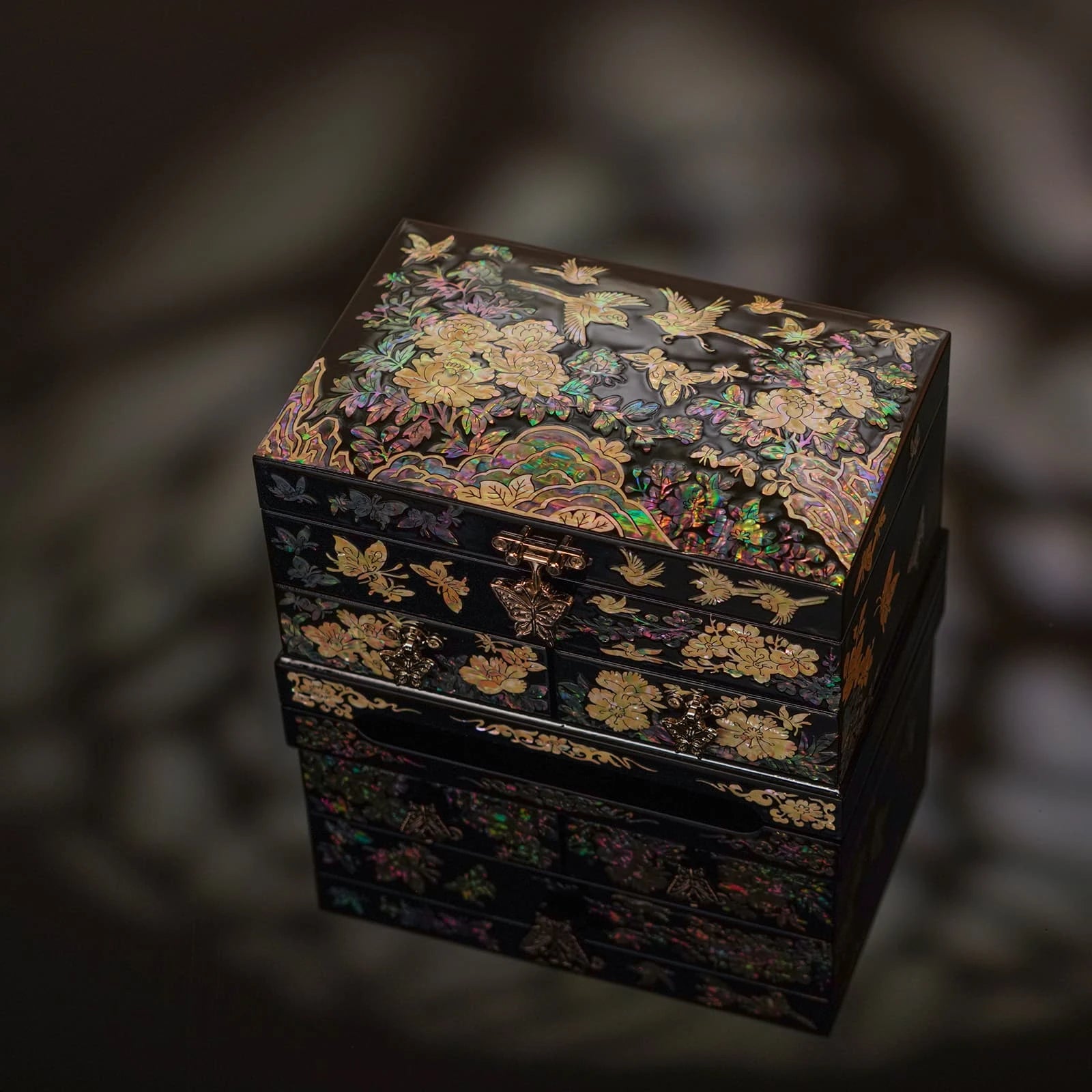 Detail view of two lower drawers featuring silver butterfly clasps and colorful nacre inlays, providing ample space for fine jewelry collection
