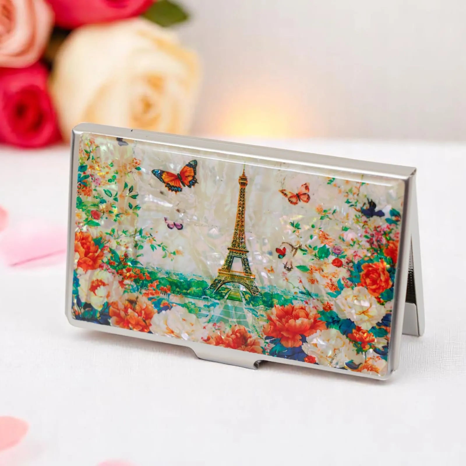 Eiffel Tower card case with butterfly and flower design on a white surface with roses
