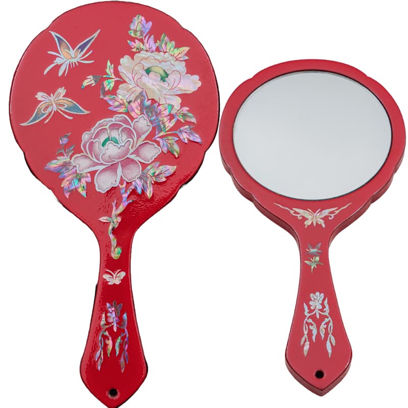 Front and back of a red hand mirror with mother-of-pearl inlay, featuring vibrant floral and butterfly designs.