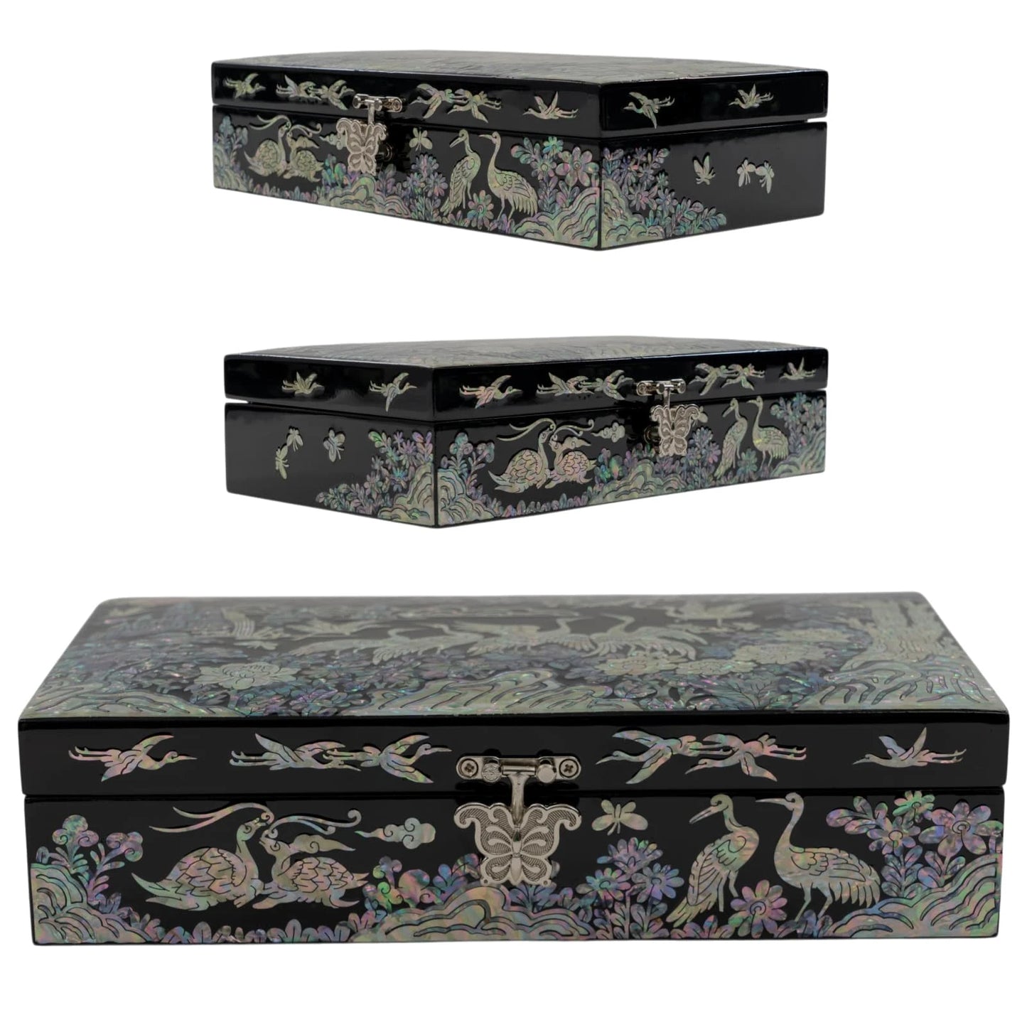Front view of a black lacquer jewelry box on a white background, featuring iridescent mother-of-pearl cranes, pine trees, and a silver clasp