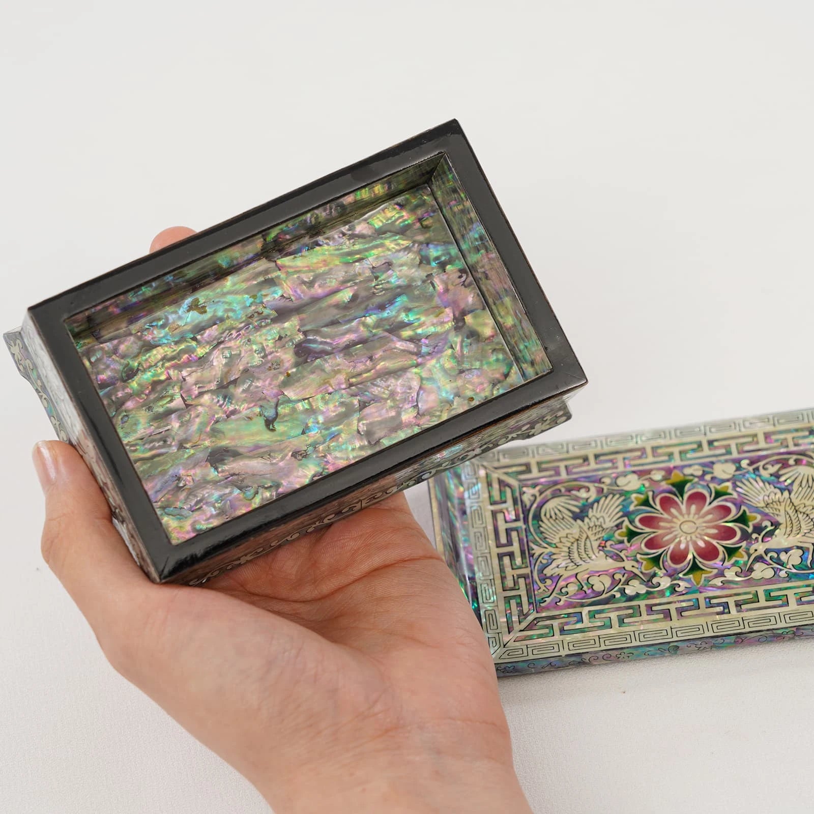 Handheld view of iridescent Mother of Pearl jewelry box interior. Showcases high-quality natural abalone inlay and handcrafted Korean Najeonchilgi