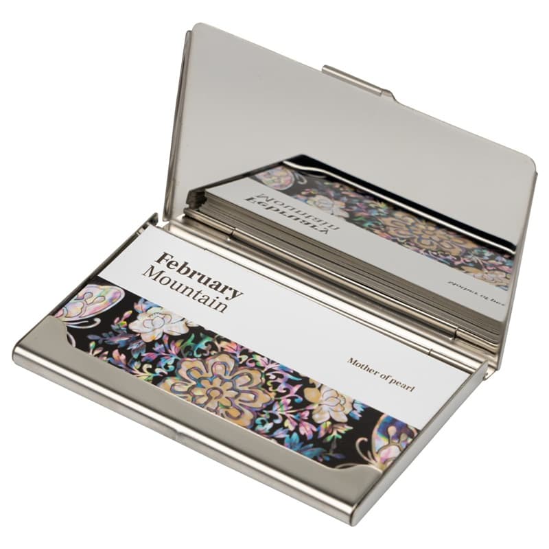 This is a silver business card holder opened to display cards.