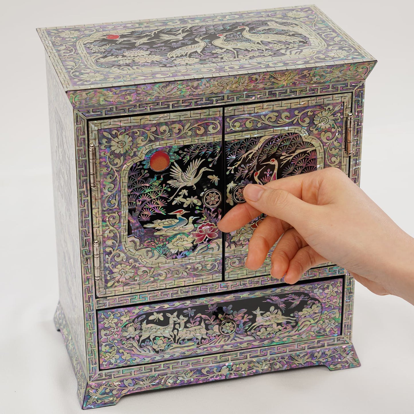 Korean mother of pearl jewelry chest closed, featuring crane, sun and floral inlay on black lacquer surface