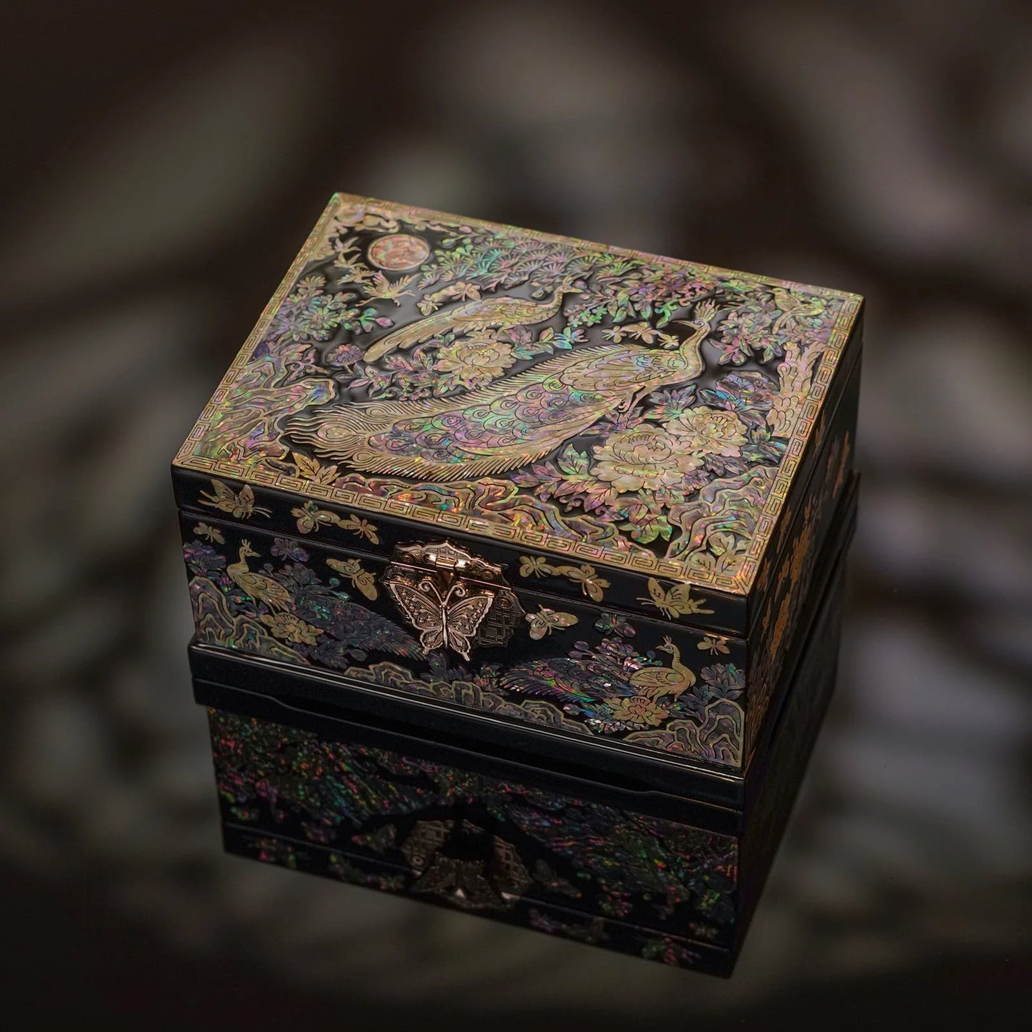 Luxurious black lacquer jewelry box with iridescent mother-of-pearl peacock and peony inlay. Features a butterfly clasp and reflective finish.