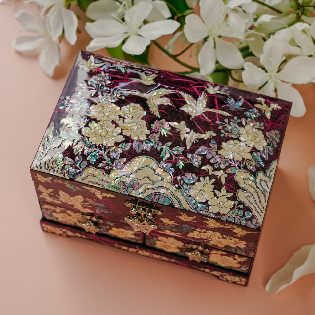 Mother-of-pearl box on pink background with white flowers