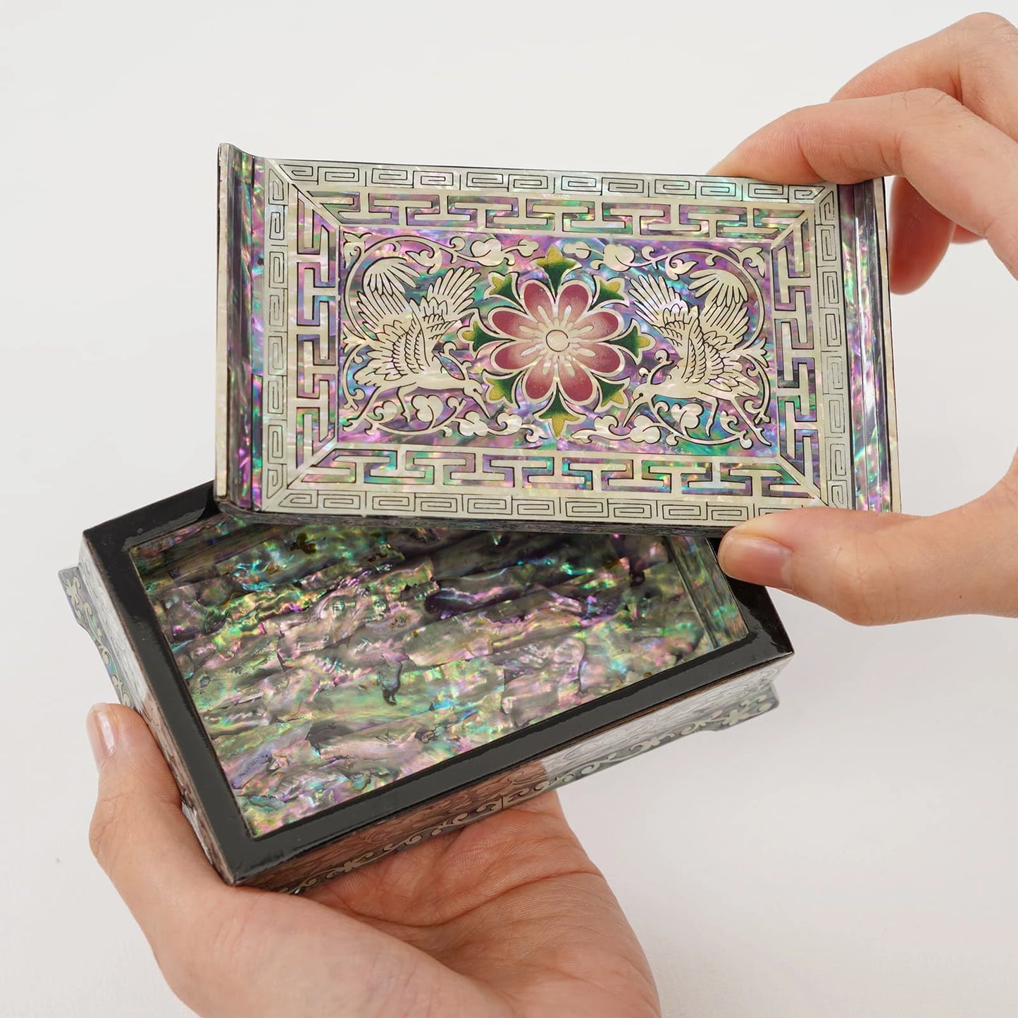 Opening a Korean lacquer jewelry box lid with crane and flower design. Exquisite mother of pearl inlay details on a black lacquerware storage case