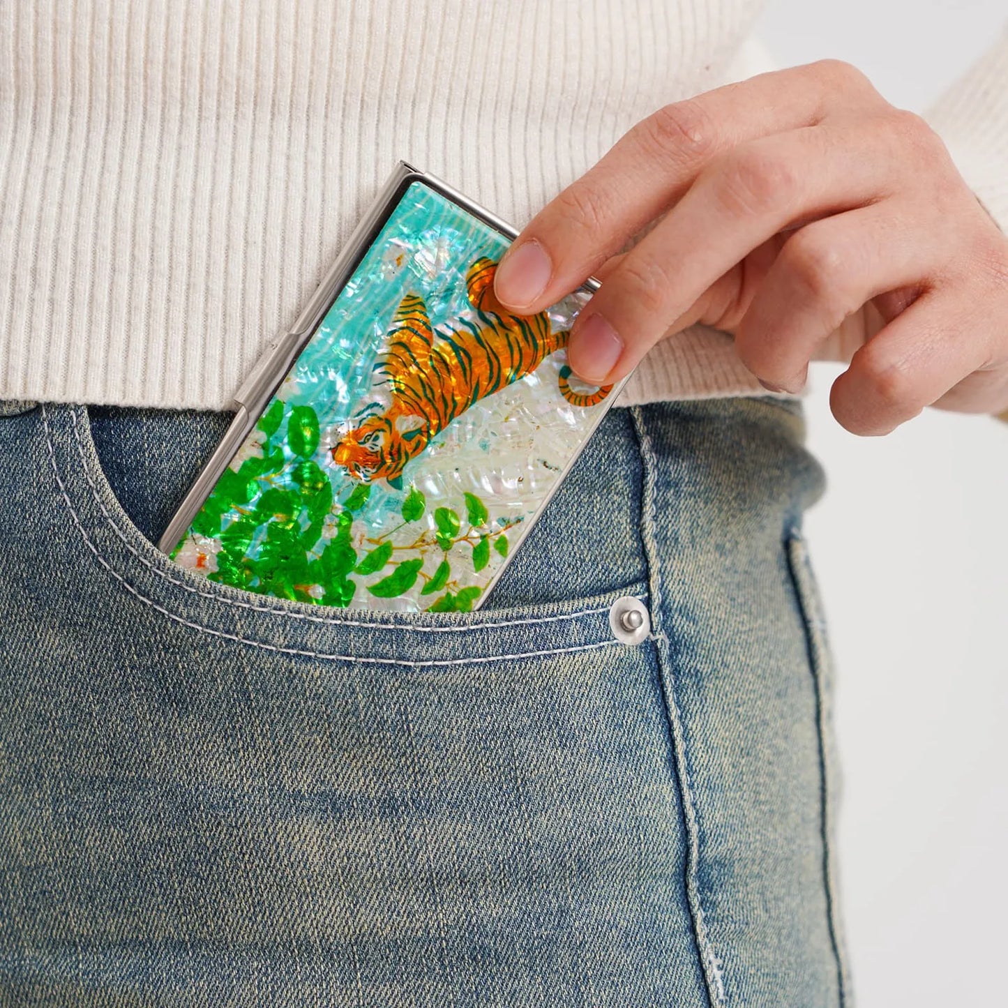 Putting a tiger design card case into the back pocket of jeans
