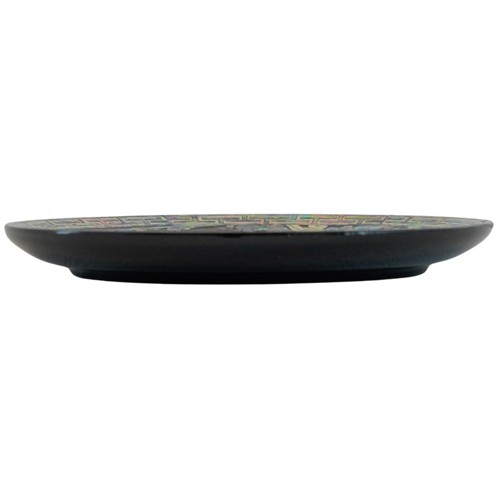 Side view of a black decorative plate with a colorful geometric edge, illustrating the plate's profile and the intricate design detail.