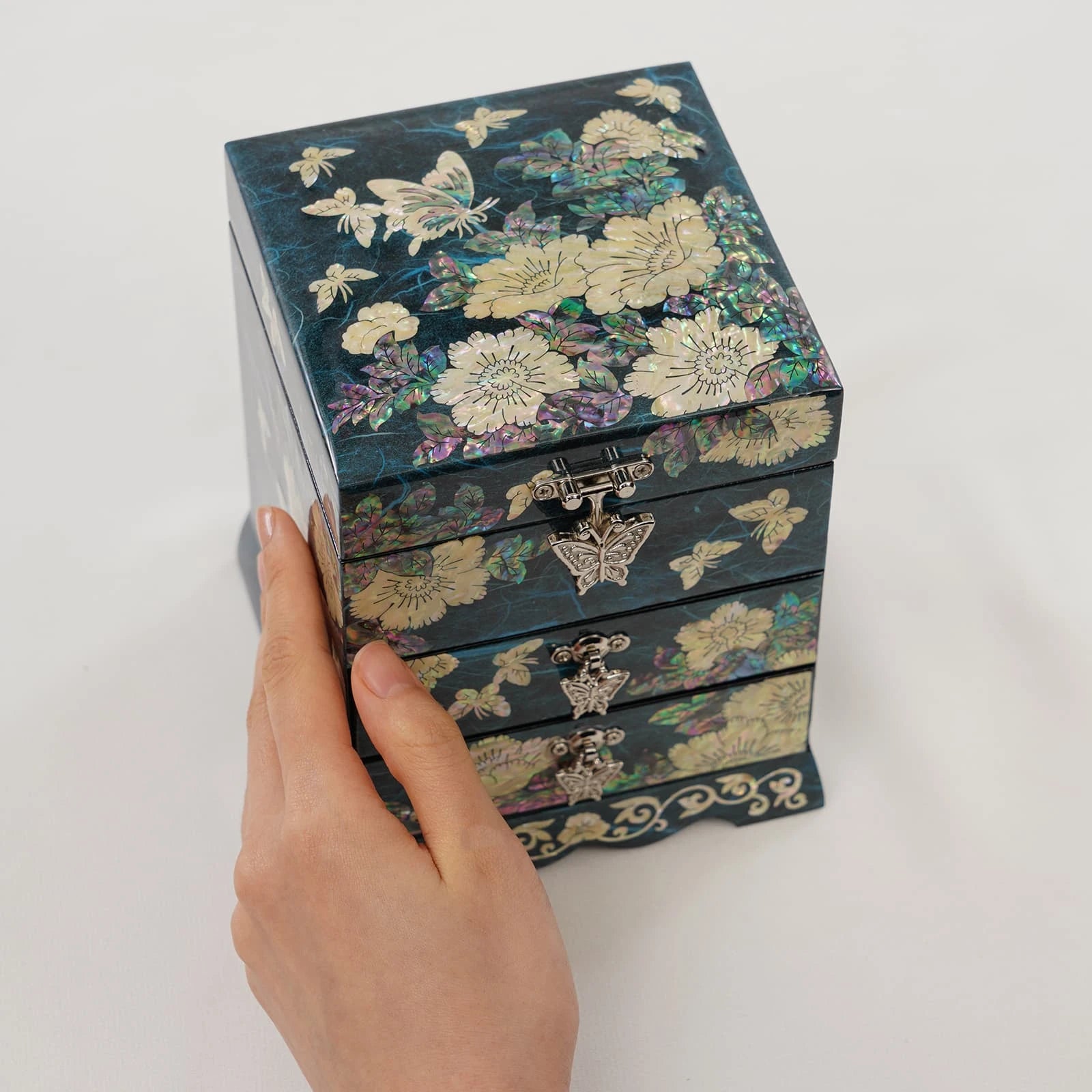 Teal blue jewelry box featuring shimmering shell inlay of butterflies and flowers. Multi-level accessory chest with vintage butterfly clasps.