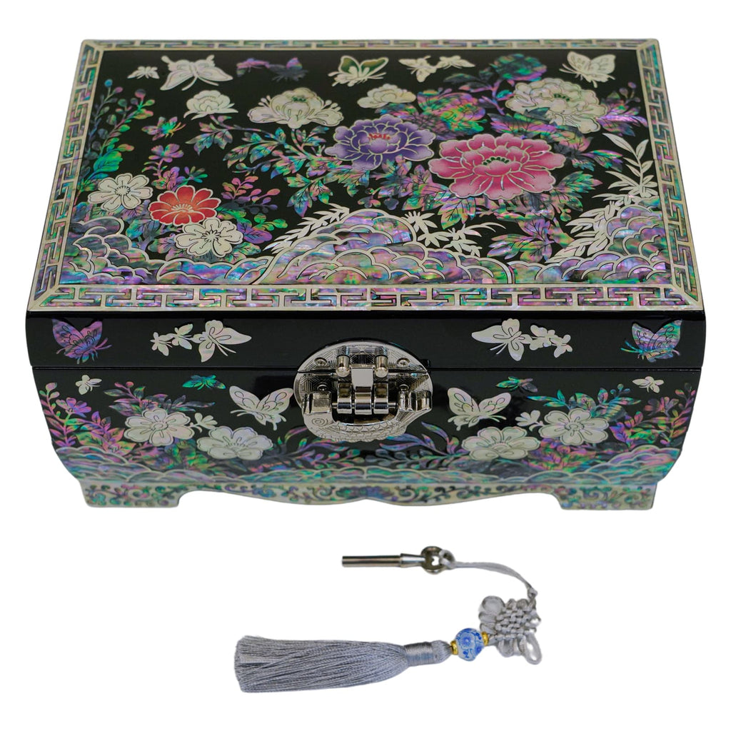 A jewelry box with a floral mother-of-pearl design and a key with a tassel, indicating it can be locked for security.