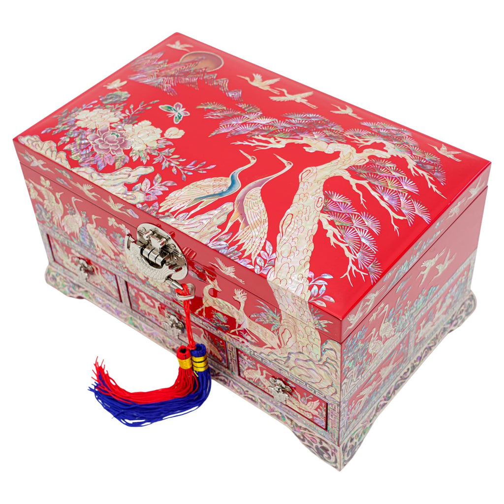 This is an image of a vibrant red traditional Korean jewelry box with intricate gold and multi-colored designs featuring birds and floral patterns, a tassel attached to the clasp.