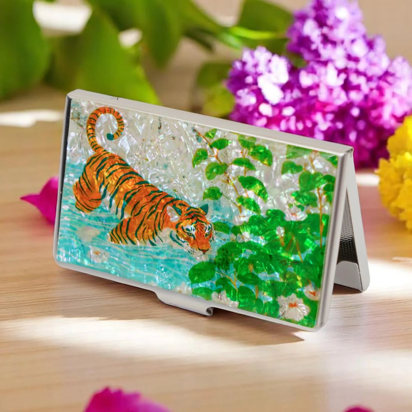 Tiger and leaves design card case standing on a wooden surface with flowers
