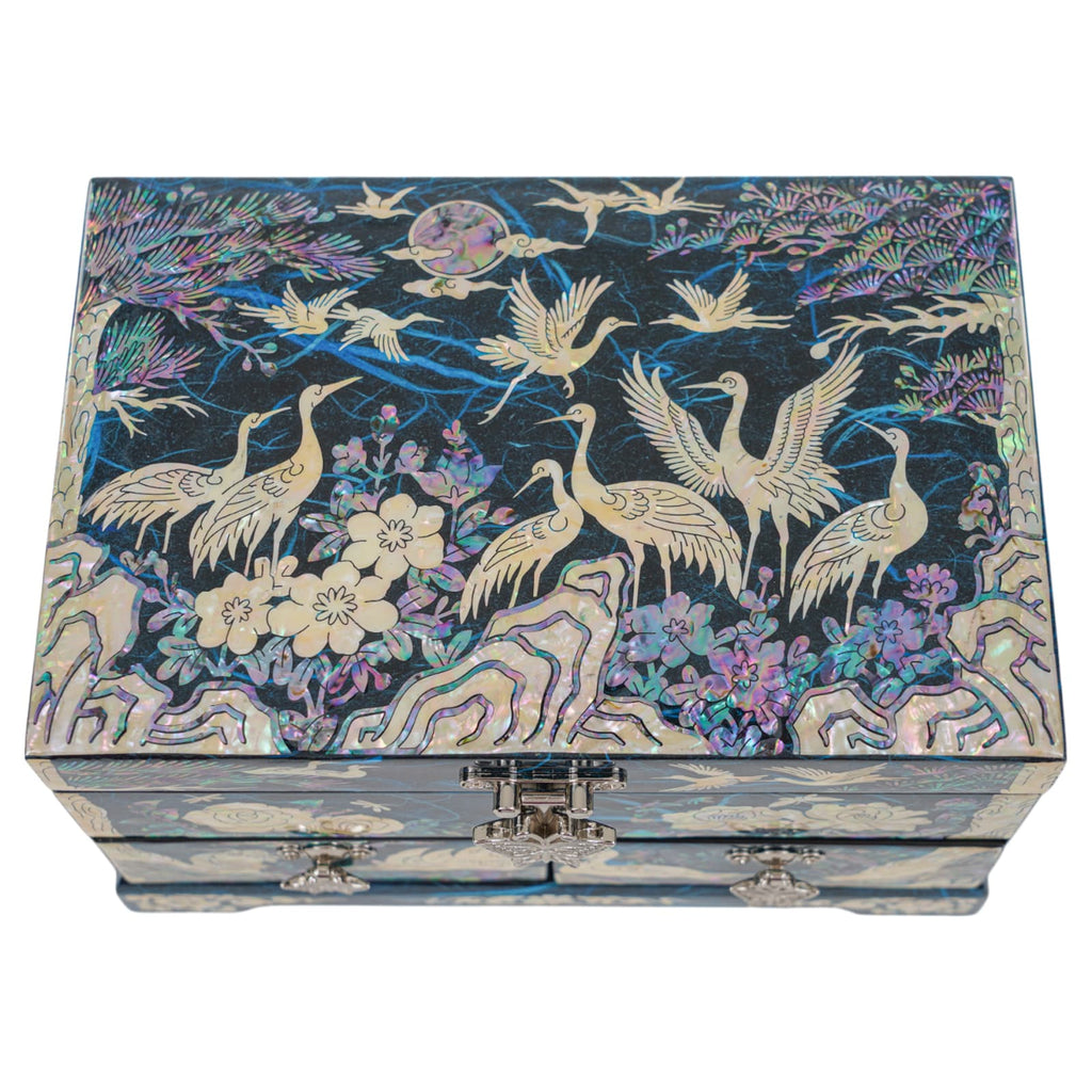Top view of crane-themed mother-of-pearl jewelry box with floral and mountain motifs