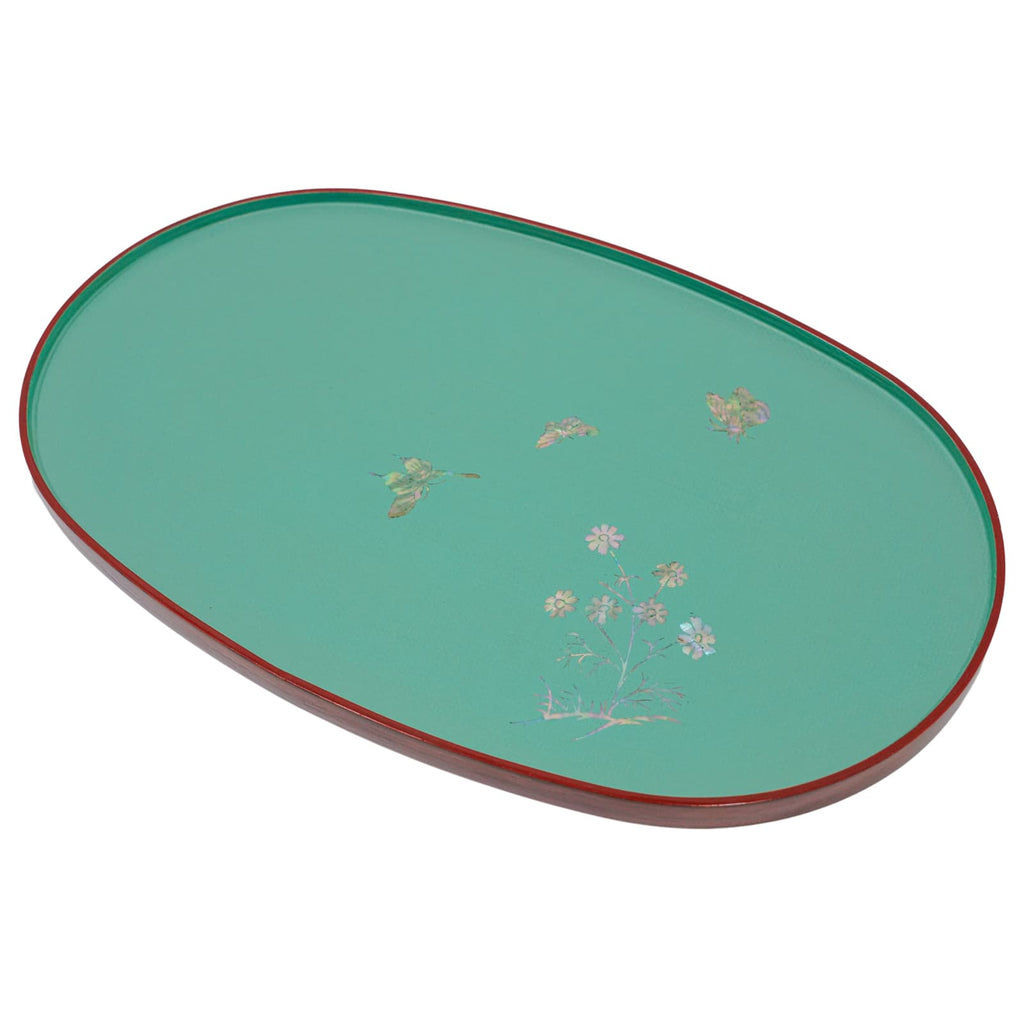A teal oval lacquered tray with a subtle mother-of-pearl floral motif and a contrasting red rim, viewed from an angle.