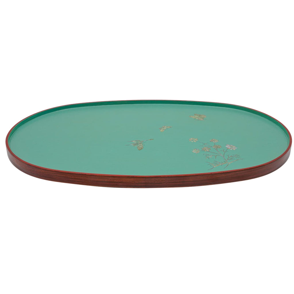 A side view of a teal oval lacquered tray with a mother-of-pearl floral design and a dark red rim.