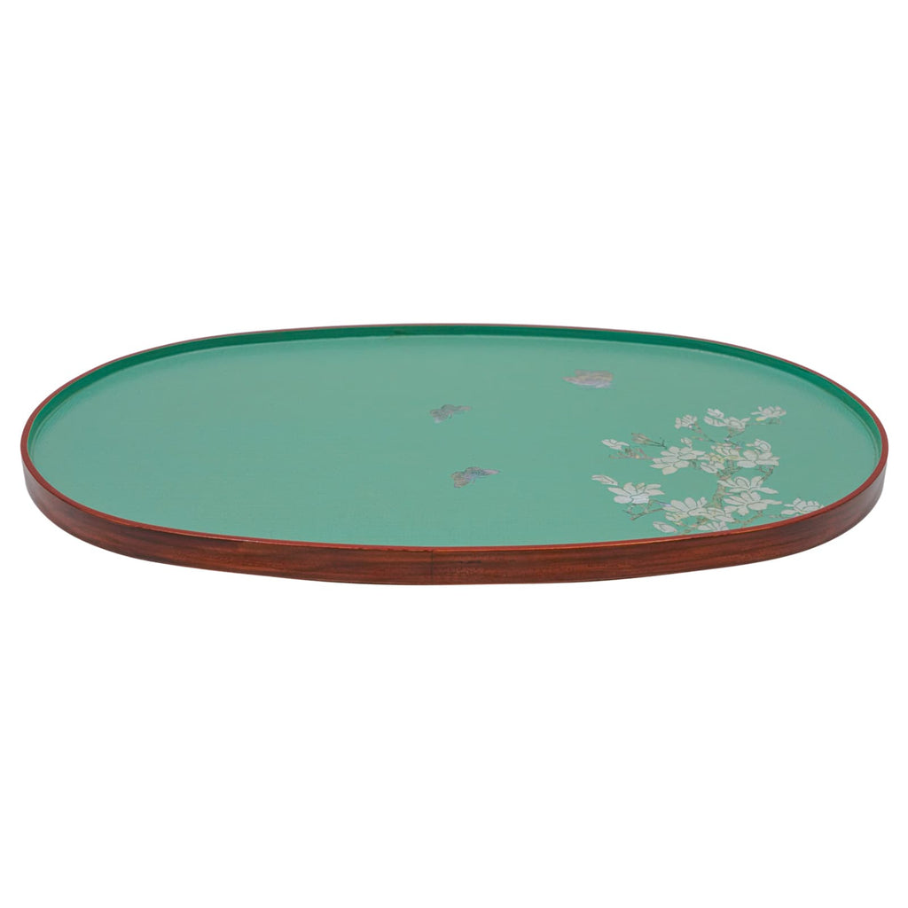 A side view of a teal oval lacquered tray with a mother-of-pearl floral design and a dark red rim.