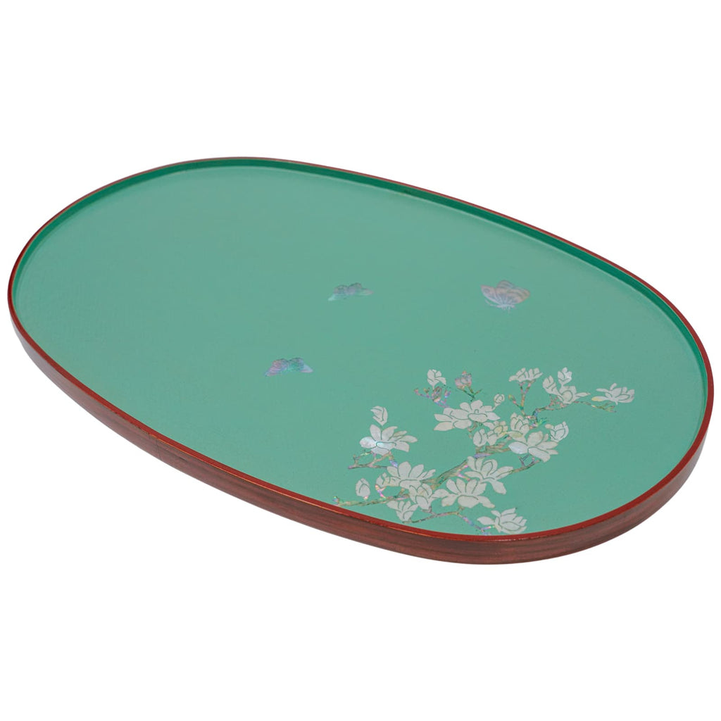 A teal oval lacquered tray with a subtle mother-of-pearl floral motif and a contrasting red rim, viewed from an angle.