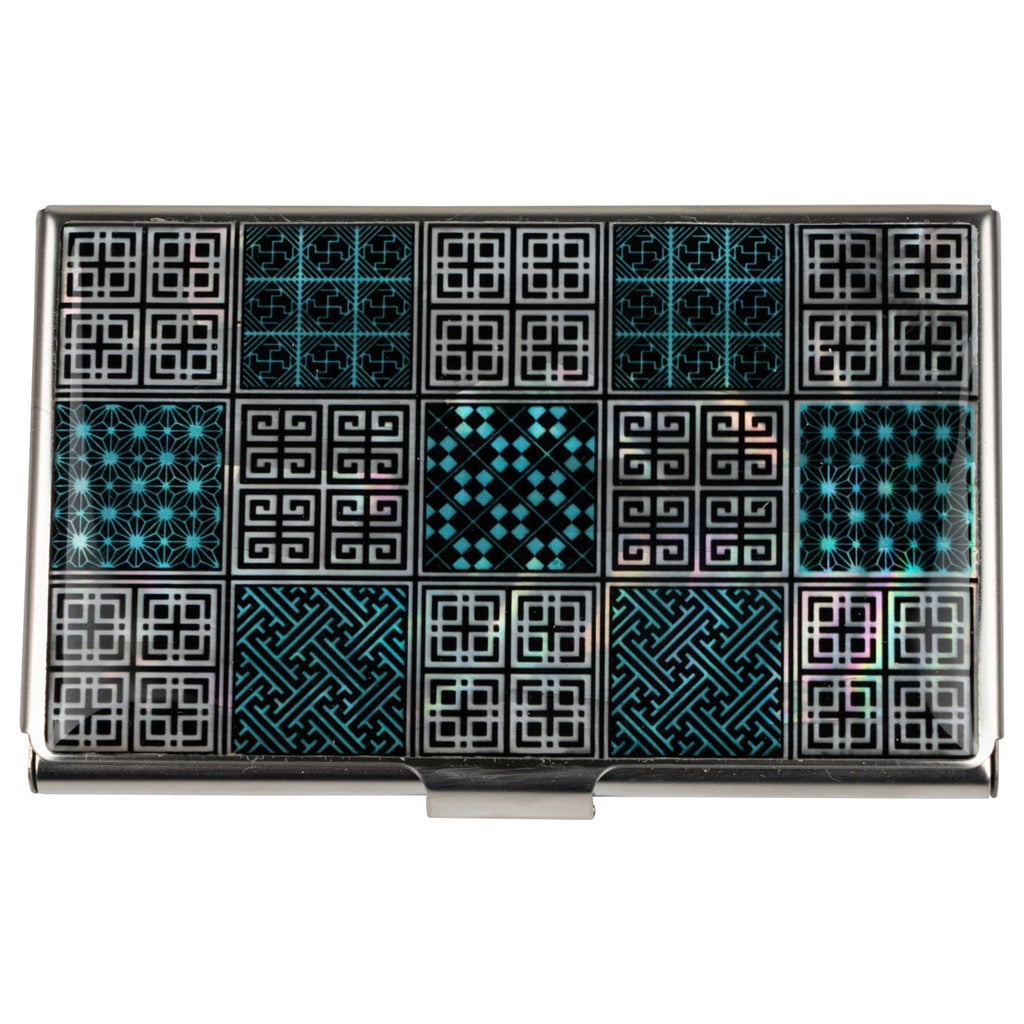 A business card case featuring a pattern of black and turquoise geometric designs, displayed within a black presentation box with a white satin lining.