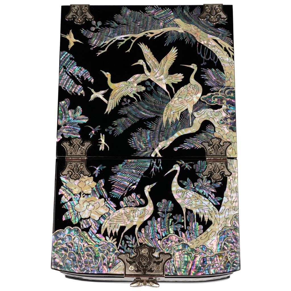 A mother-of-pearl folding mirror jewelry box with elaborate designs of cranes and flora on a black background, showcasing detailed artisanship.