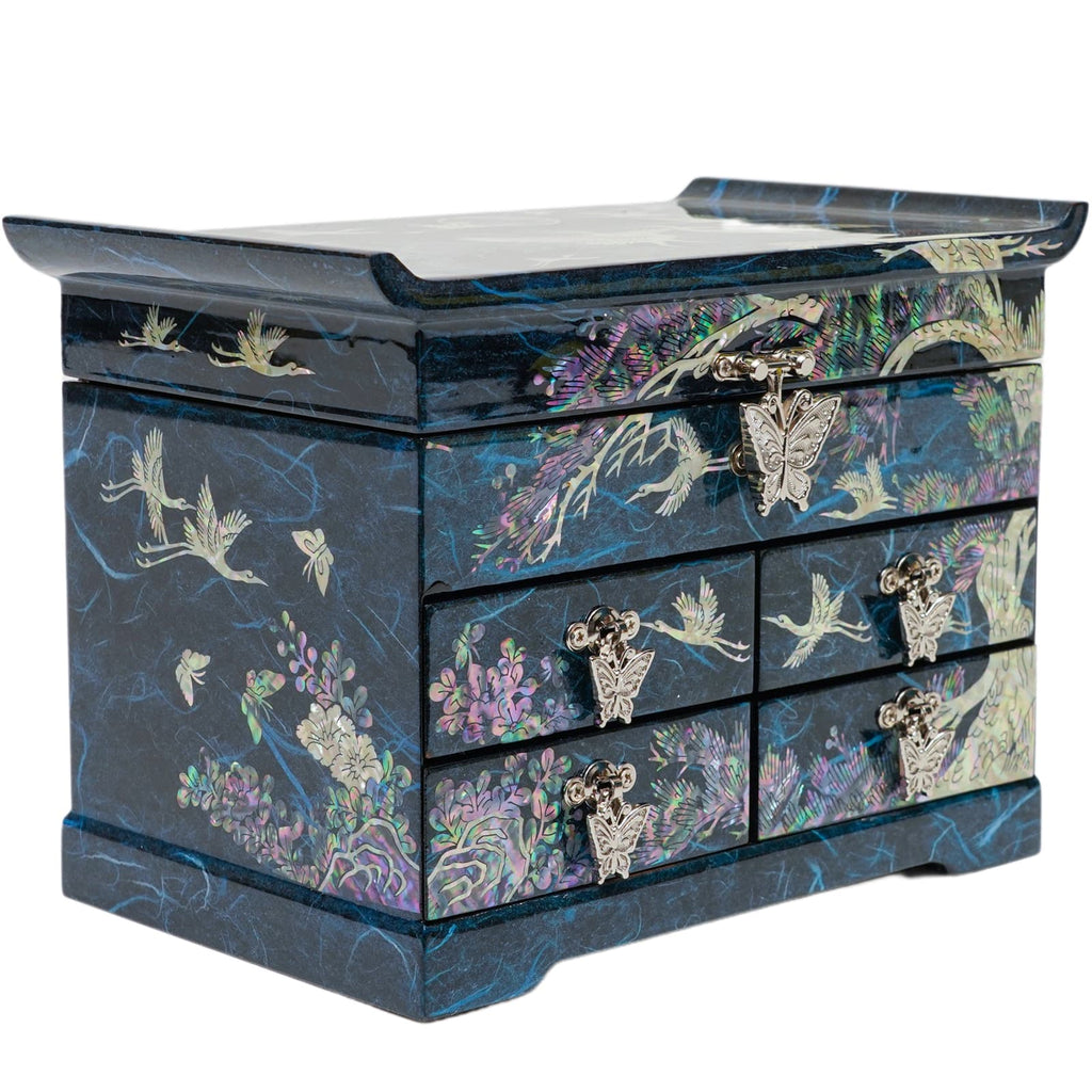 A blue mother-of-pearl jewelry box with multiple drawers, featuring intricate butterfly handles and traditional Korean crane and floral designs, on a reflective surface.