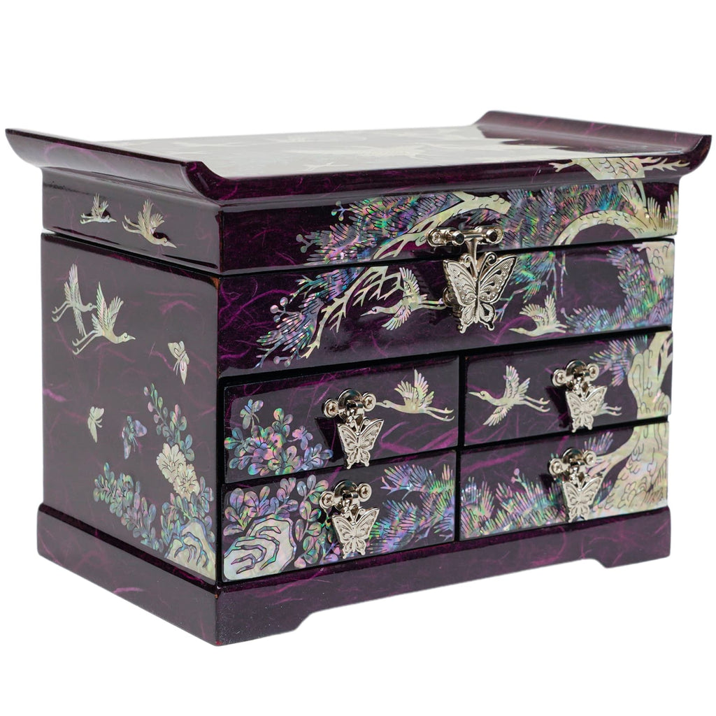 A purple mother-of-pearl jewelry box with multiple drawers, featuring intricate butterfly handles and traditional Korean crane and floral designs, on a reflective surface.