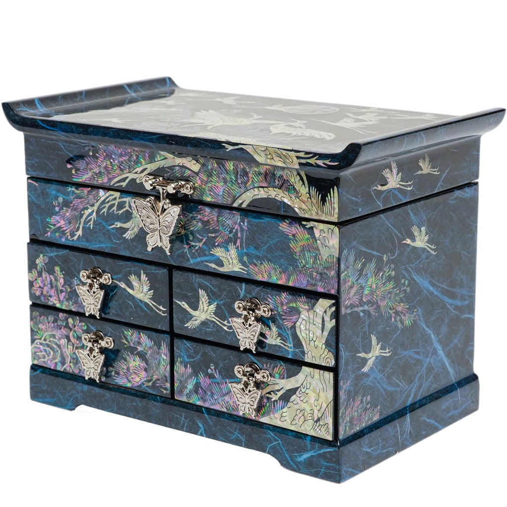 A blue Korean mother-of-pearl jewelry box with crane, pine tree, and butterfly designs, featuring multiple drawers with metal handles.