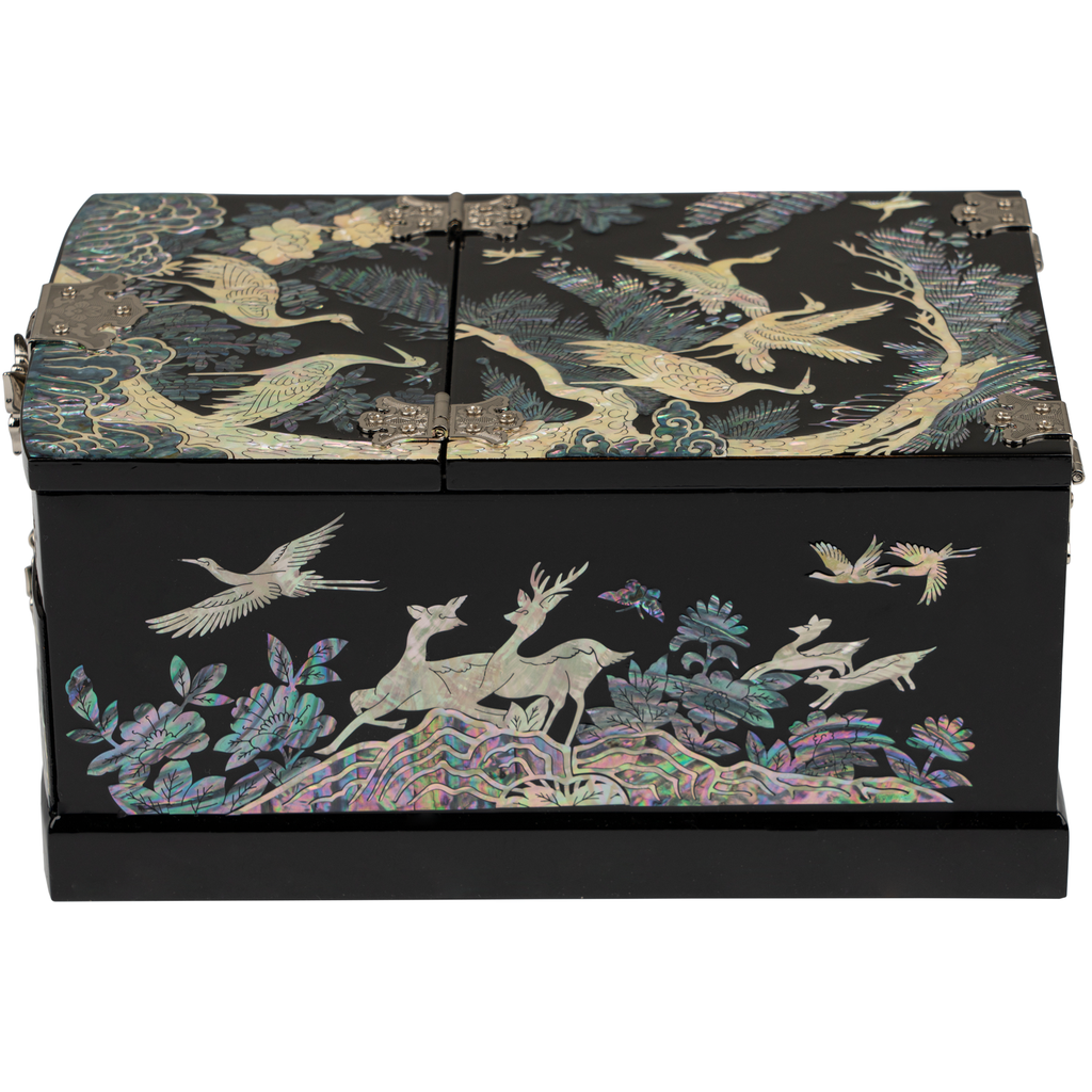 A closed jewelry box with mother-of-pearl inlays featuring cranes and deer among lush foliage on a black lacquer base, displaying detailed craftsmanship.