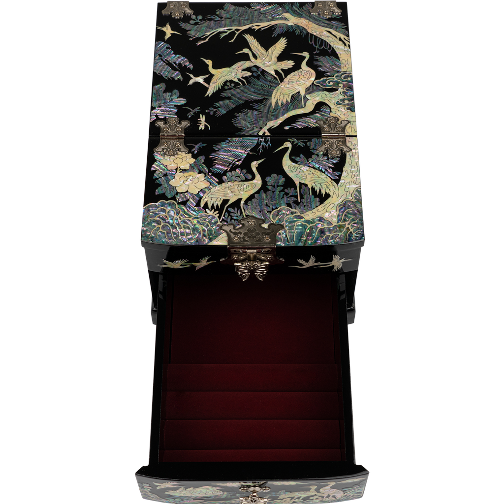 An elaborate black jewelry box with a red interior and oriental bird designs on the outside, isolated on a background.
