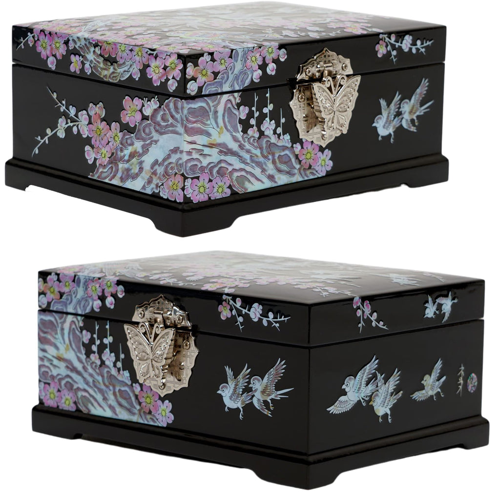 A black jewelry box with mother of pearl inlay showing birds and plum blossoms on the sides and a marbled pattern on top, with a metallic butterfly clasp.