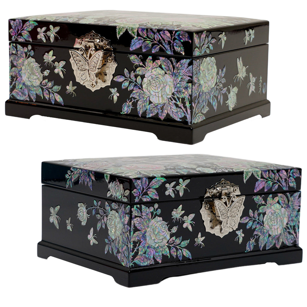 A black lacquered jewelry box with mother of pearl inlay depicting roses and butterflies on its sides, complemented by an ornate butterfly-shaped clasp.