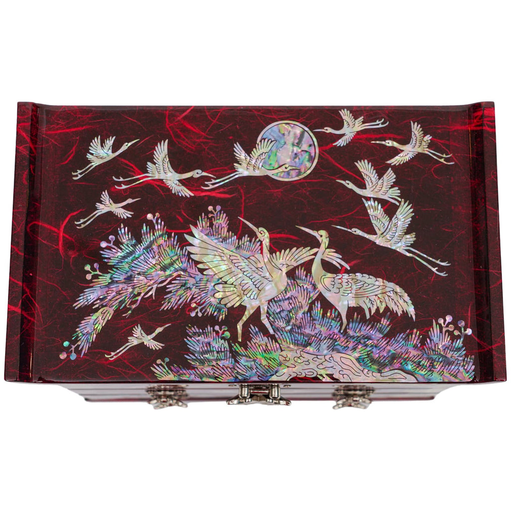  A mother-of-pearl jewelry box with a pine tree and crane design in vibrant colors, featuring two butterfly clasps on the front.
