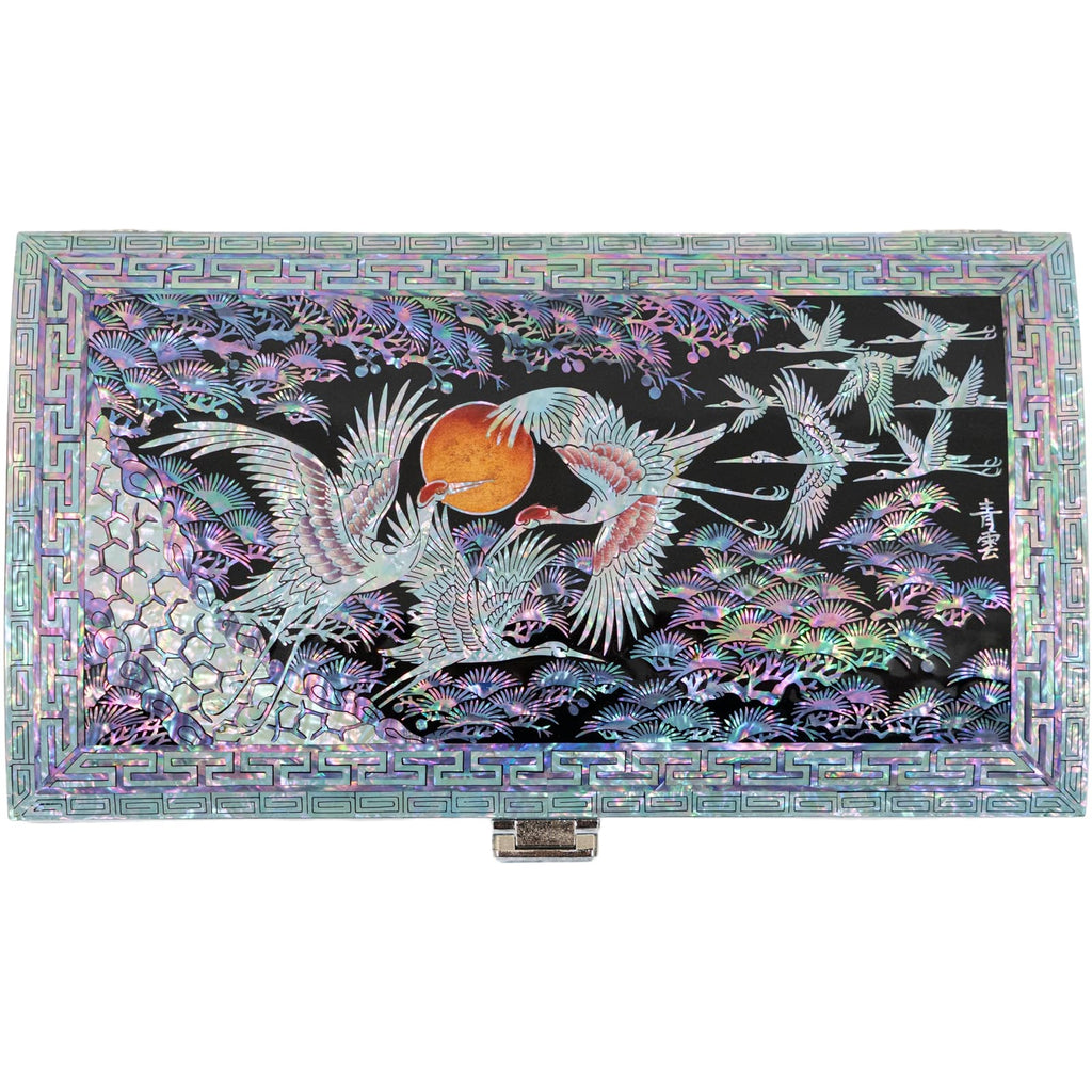 A rectangular Mother of Pearl box depicts a crane, sun, and pine tree on its lid, set against a geometric patterned background