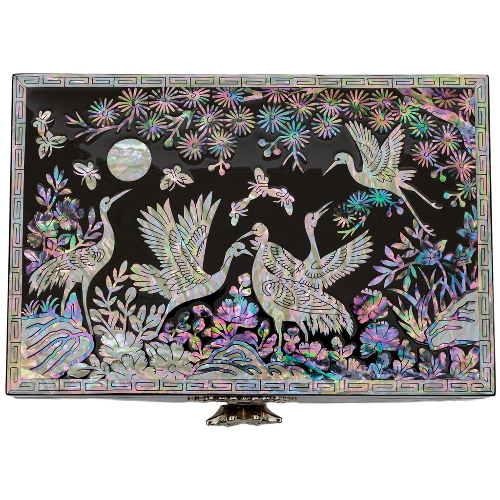 A large black jewelry box with a detailed mother-of-pearl inlay showcasing a moonlit scene with cranes and flowers, highlighting the lustrous and colorful artistry.