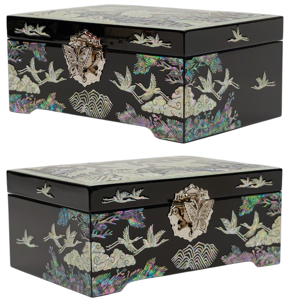  A black jewelry box with a lustrous mother-of-pearl inlay featuring cranes and nature motifs on the lid and sides. The box has a metal butterfly clasp and intricate border design.
