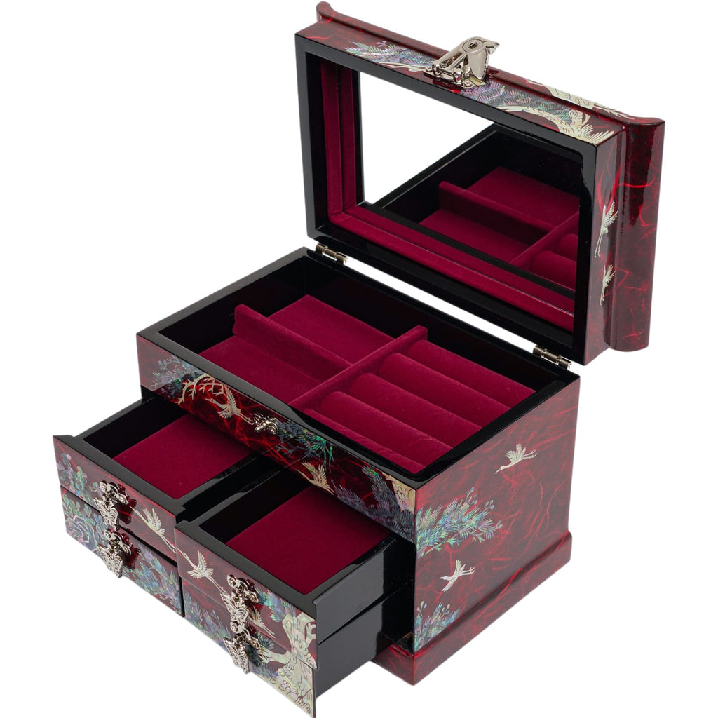 A red mother-of-pearl jewelry box open to reveal a mirror and plush red interior, with multiple compartments and drawers for storage, accented with crane designs.