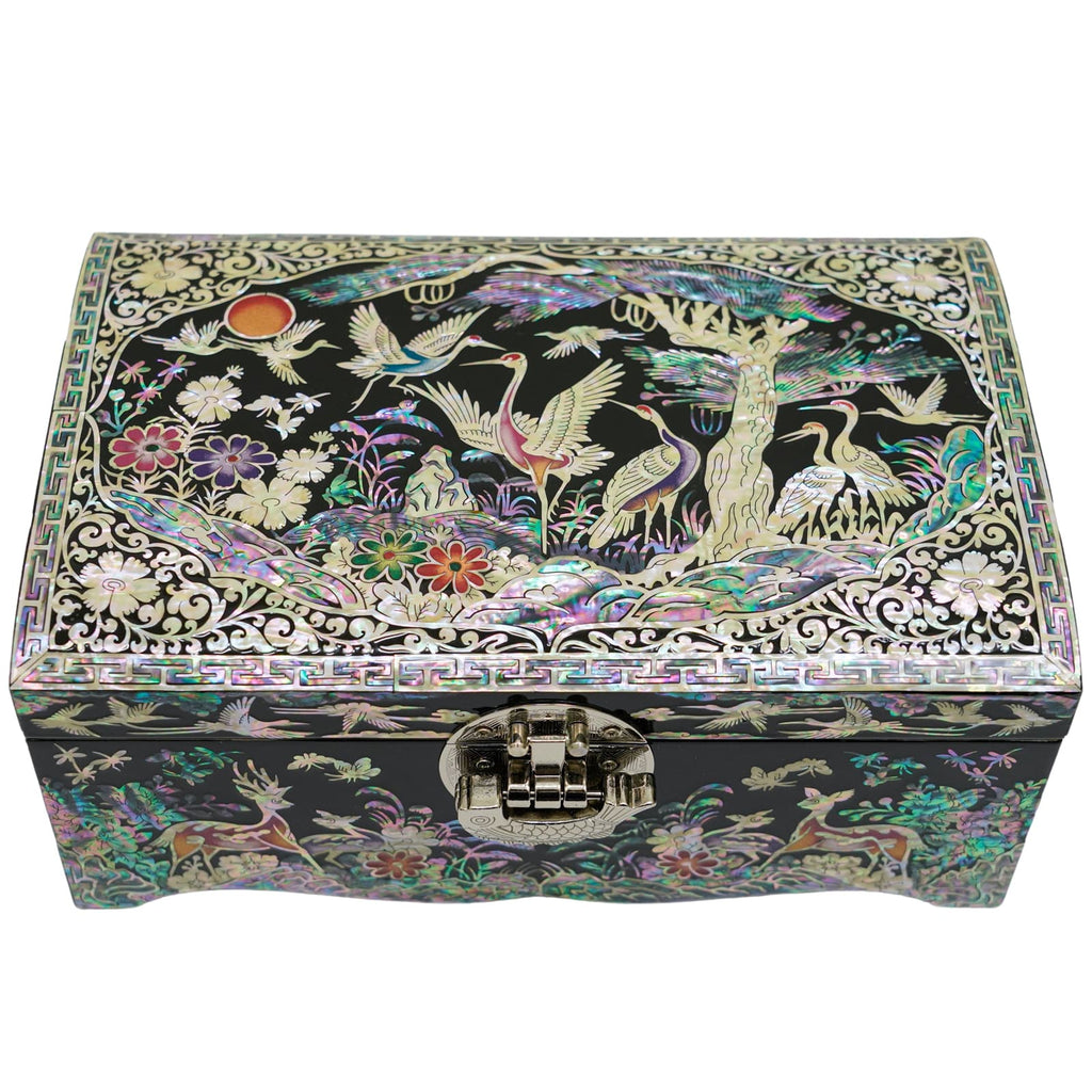  An elegant Mother of Pearl box adorned with cranes and flora, featuring a luminous finish with intricate trees, and a geometric frame. It has a sturdy latch to safeguard treasures and showcases beautiful detail.