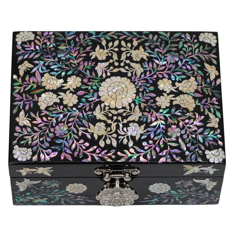 A jewelry box with a dense mother-of-pearl floral pattern on a black surface, accentuated with a detailed metal clasp in the front.
