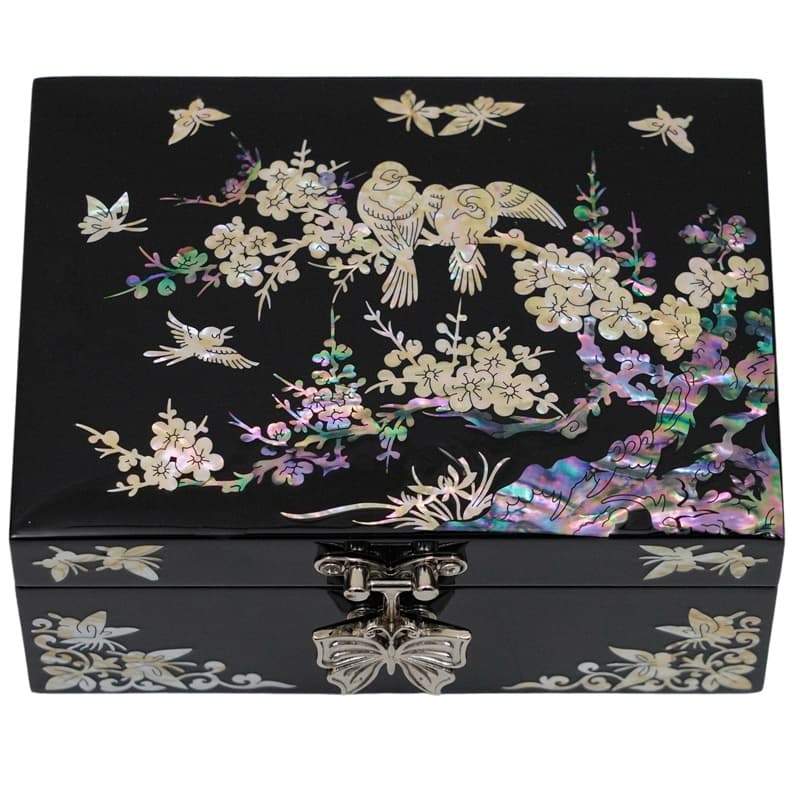 A jewelry box with mother-of-pearl inlays depicting birds and plum blossoms on a black surface, with a butterfly-shaped clasp.