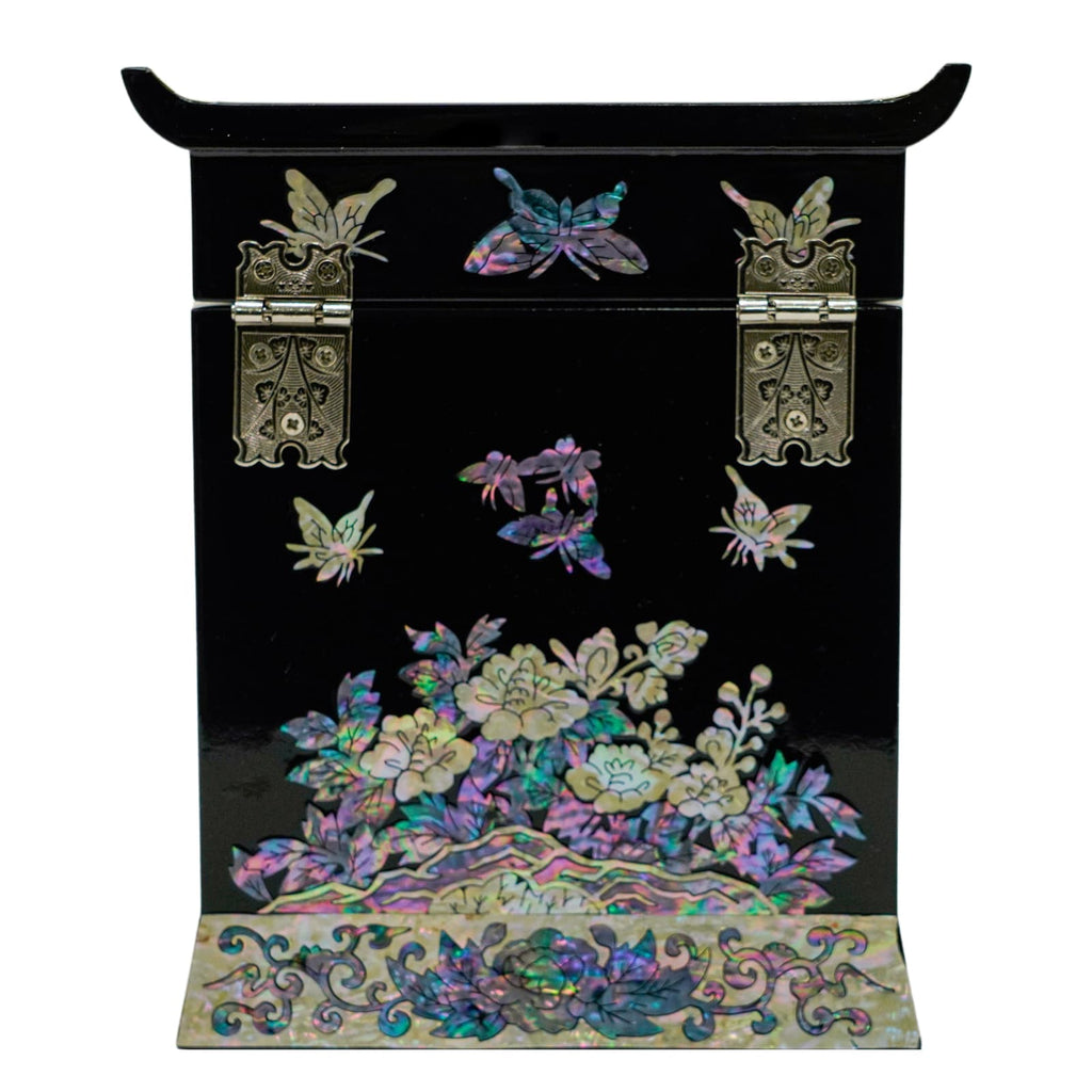 A black jewelry box's back side, with traditional hinges and mother-of-pearl inlay depicting butterflies and florals.