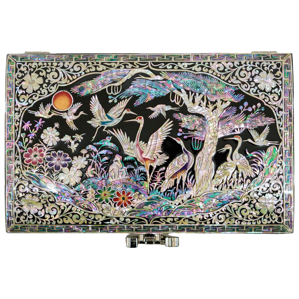 A lustrous Mother of Pearl box adorned with soaring cranes, vibrant blossoms, and delicate trees, showcasing exquisite artistry and detail, surrounded by a geometric border.