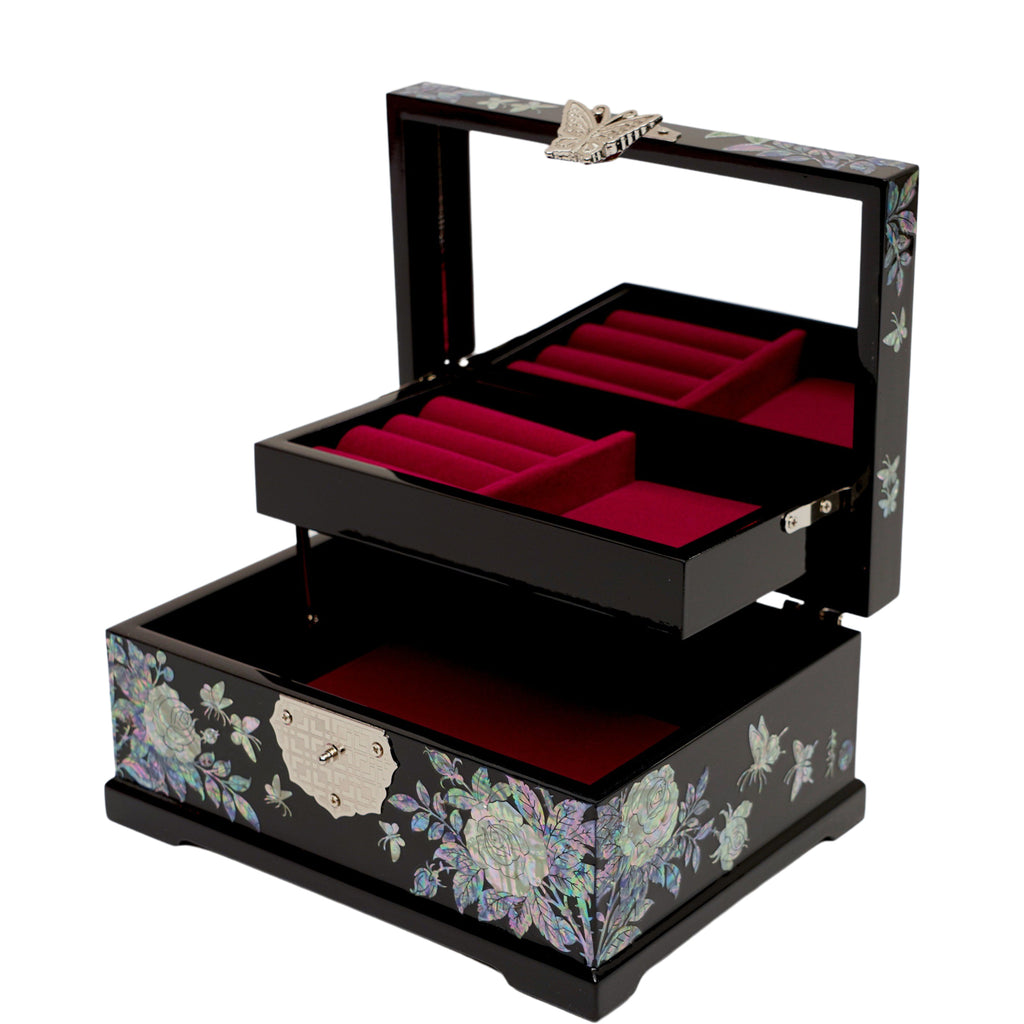An open, black lacquered jewelry box with red velvet compartments, a mother of pearl rose and butterfly design on the exterior, and a butterfly handle on the mirror.