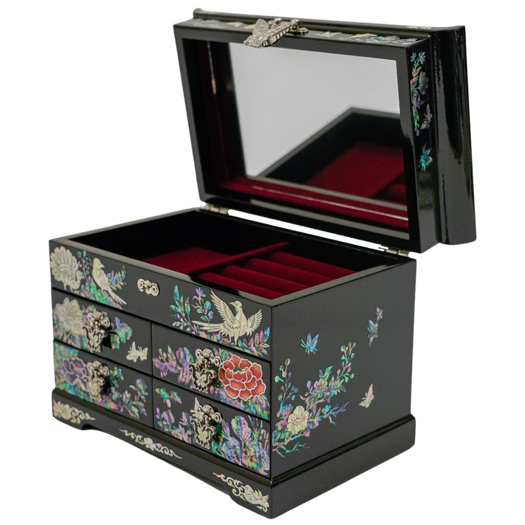 An elegant black lacquer jewelry box adorned with mother-of-pearl bird and flower motifs, featuring a mirrored lid and red velvet interior with multiple compartments.