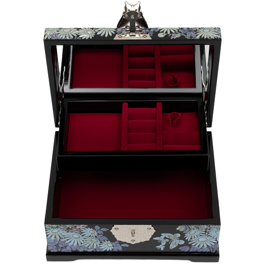 An open black jewelry box with a mother-of-pearl chrysanthemum design, red velvet-lined compartments, and a butterfly-shaped clasp on the mirror.
